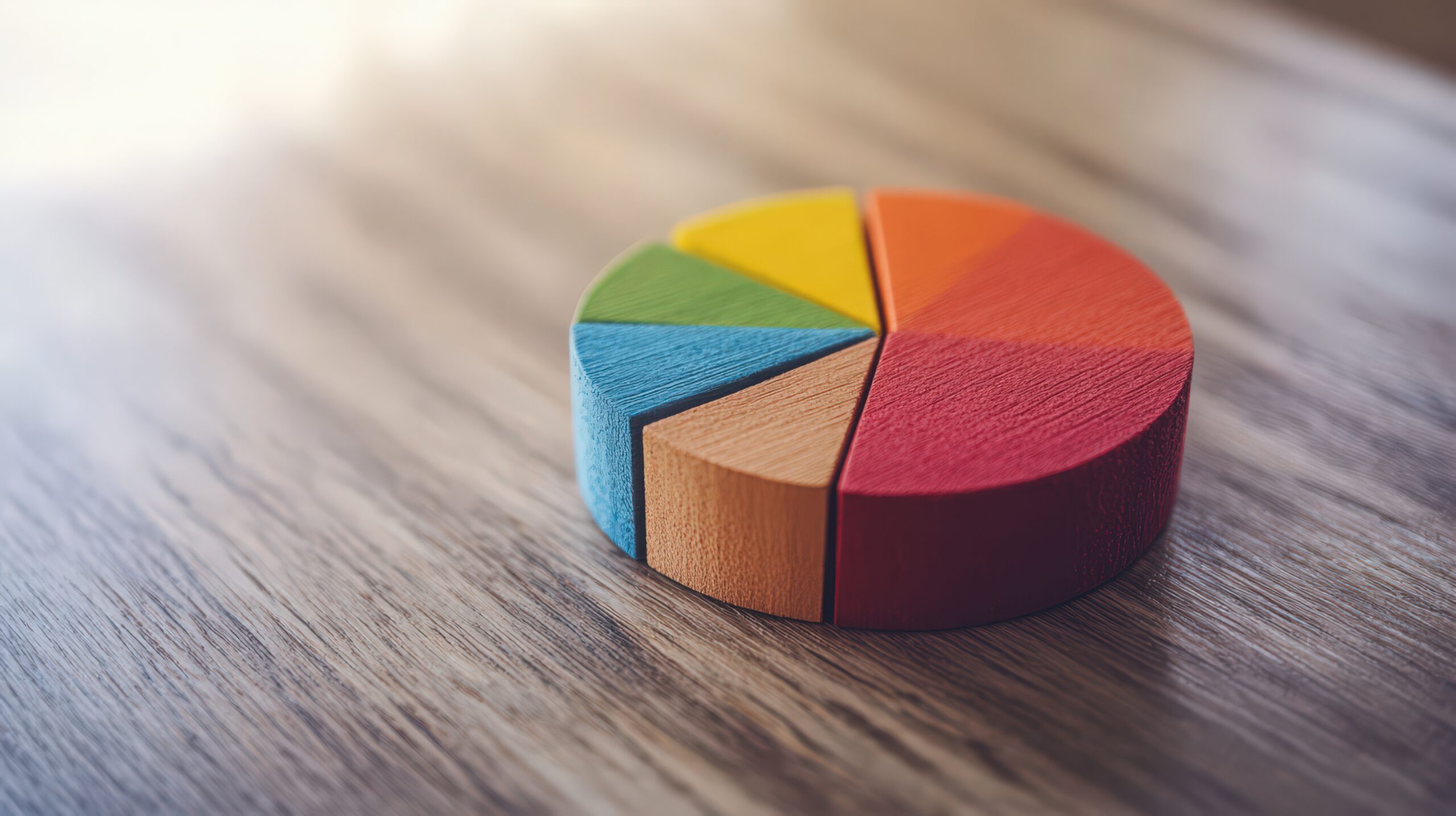 Colorful Wooden Block Pie Chart on Wooden Surface Representing Data Analysis